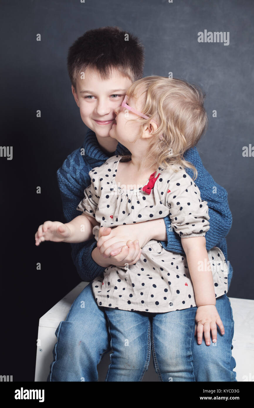 Sister Kissing Brother. Small Girl and Boy Stock Photo