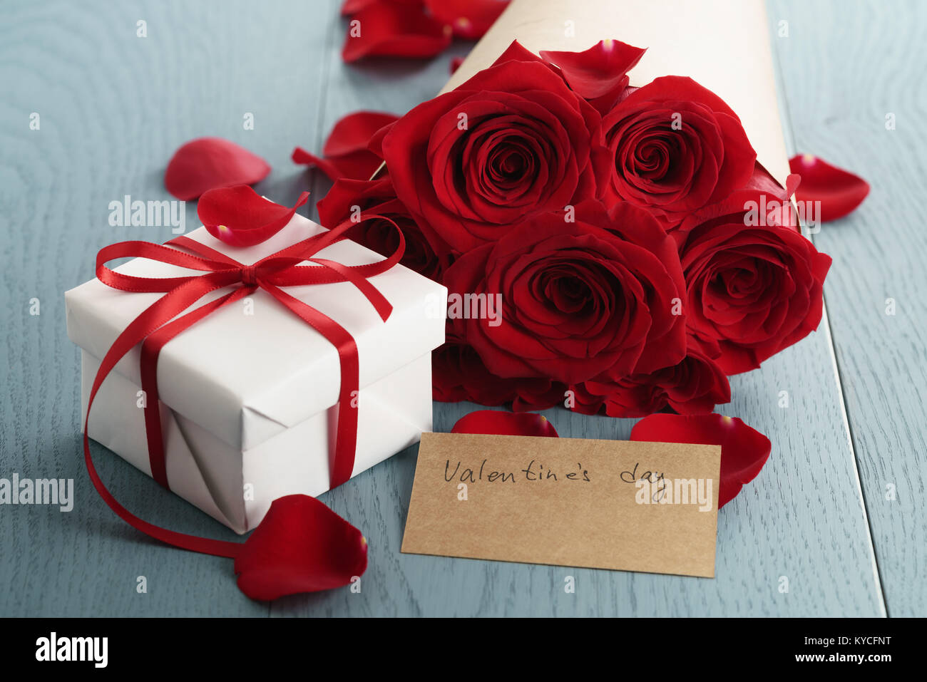 gift box with red roses bouquet for valentines day on blue wood table ...