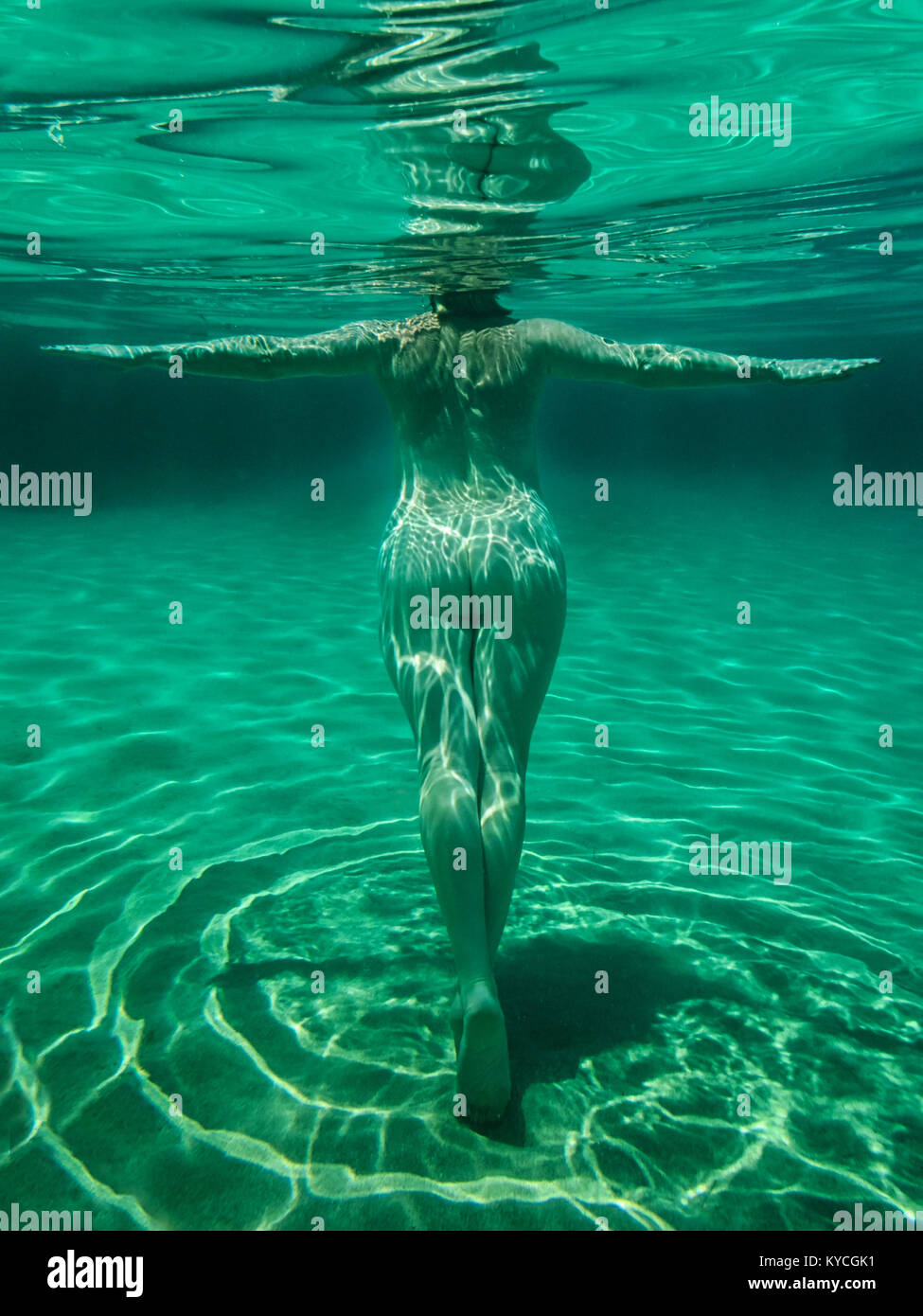 Naked woman swimming and diving in the Mediterranean Sea off the coast of  Ibiza Spain at the nudist beach Cala Conta Stock Photo - Alamy