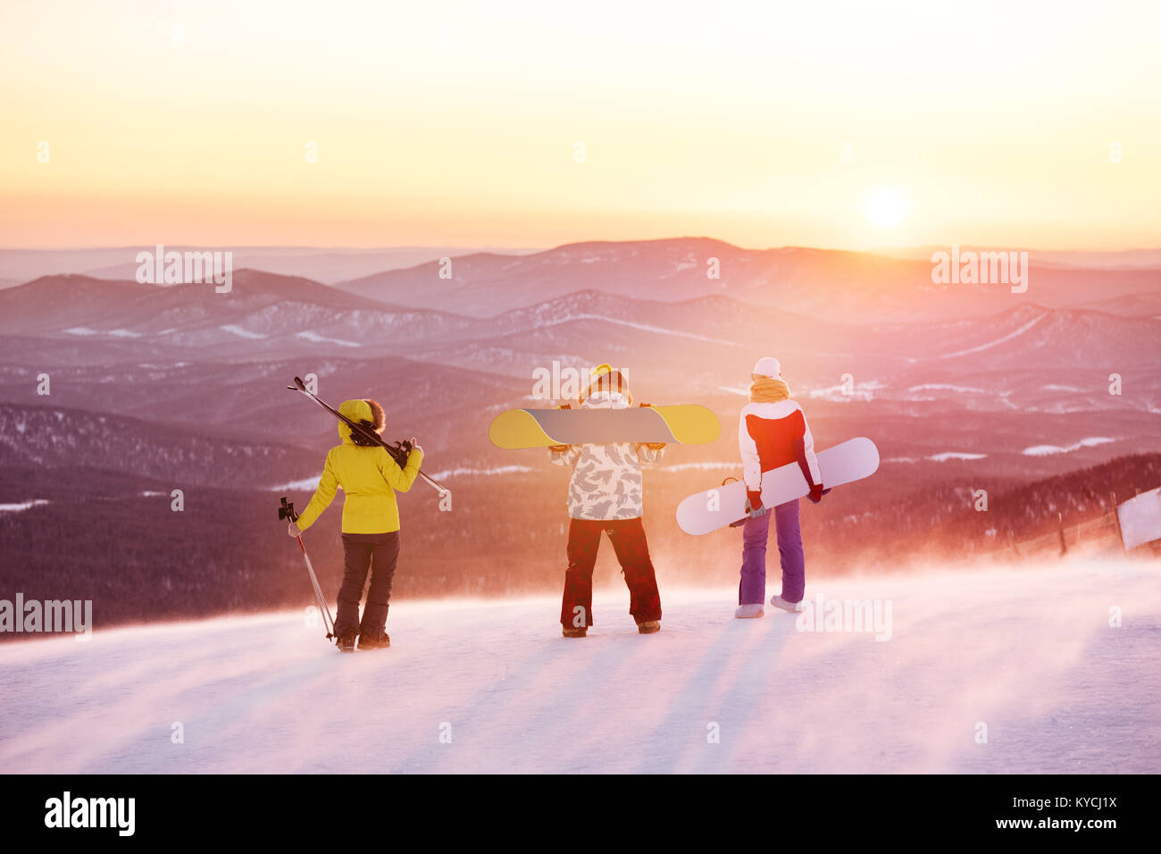 Friends at ski resort against sunset Stock Photo