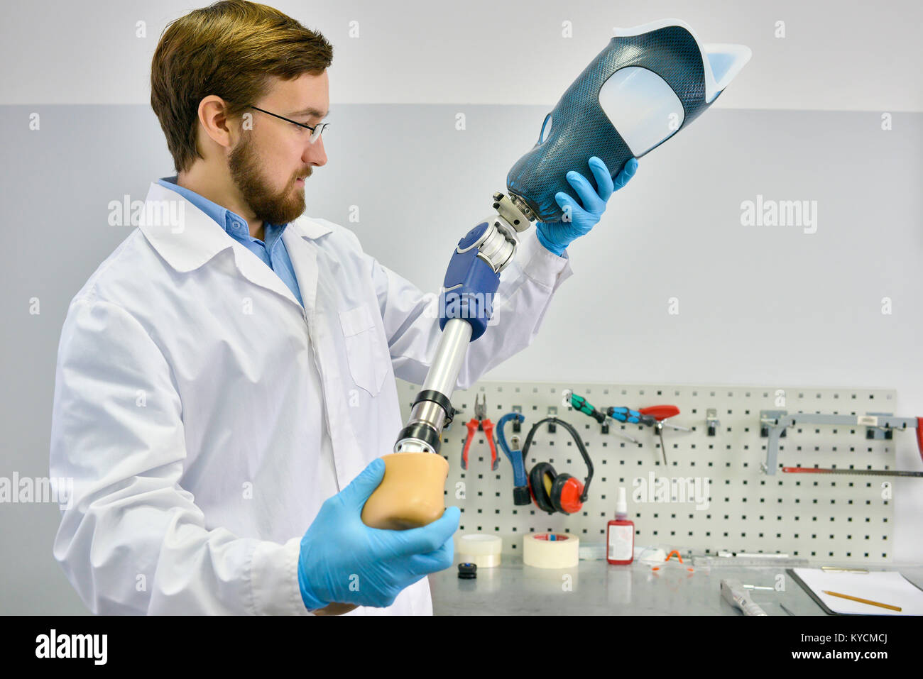 Portrait of young prosthetics technician holding prosthetic leg