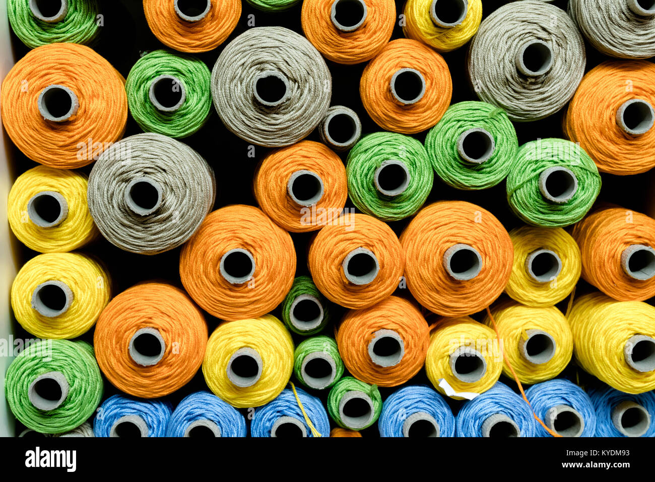 many colorful spools of thread used for weaving on a traditional loom