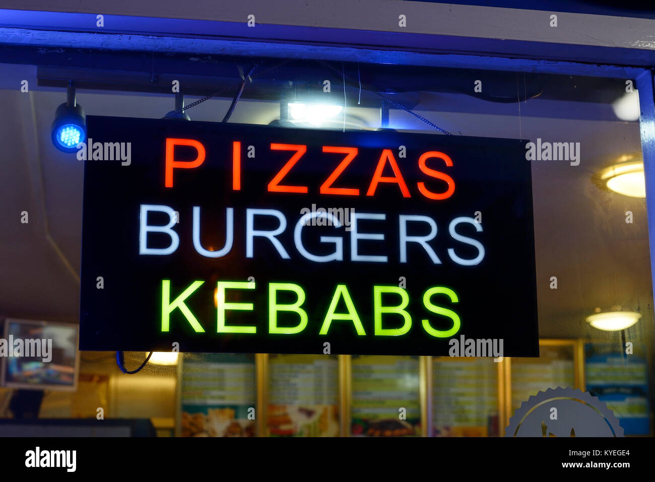 Pizzas Burgers Kebabs sign in the window of a takeaway restaurant Stock Photo