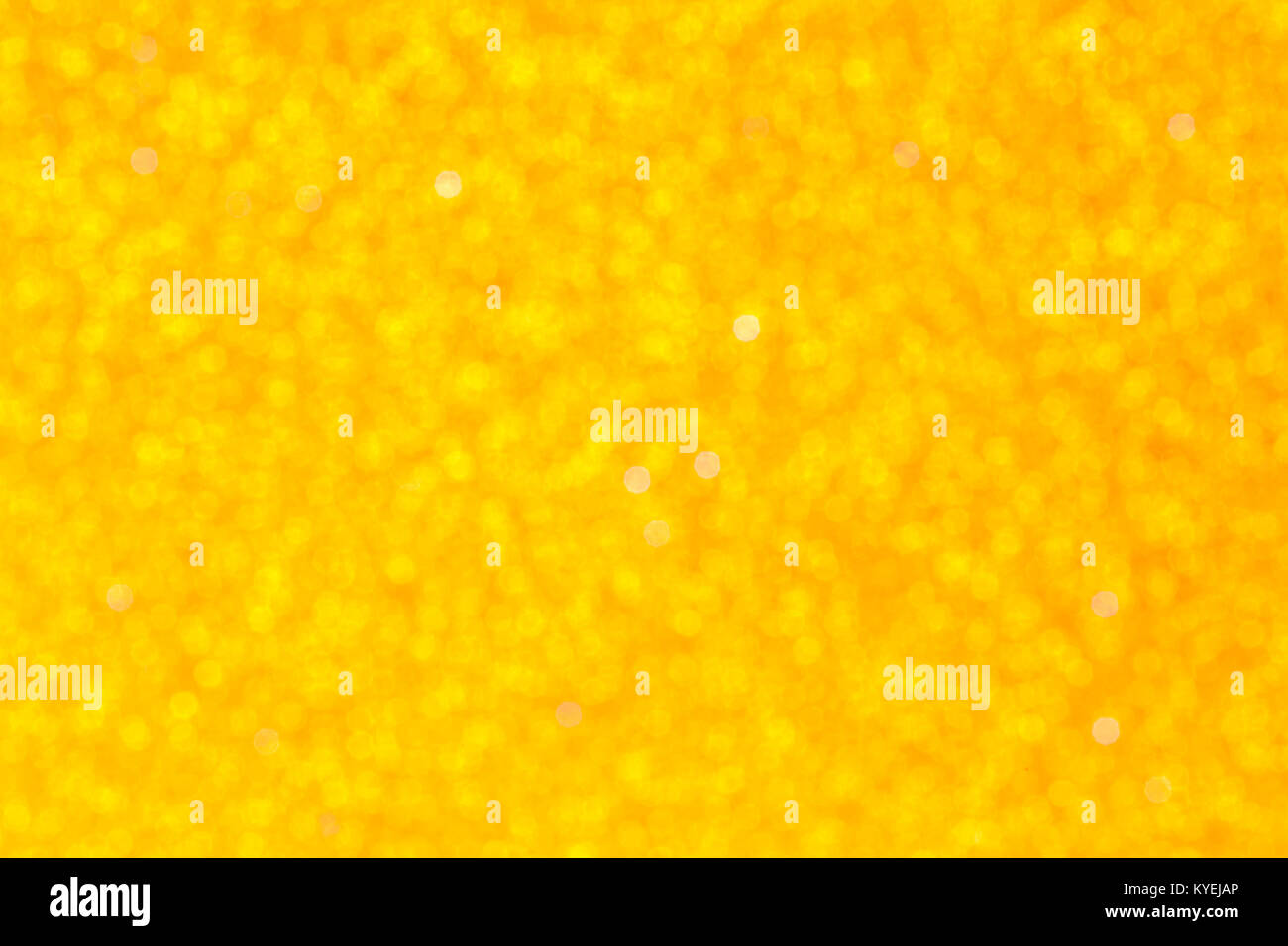 yellow glitter foam sheet textured texture background - out of focus with bokeh Stock Photo