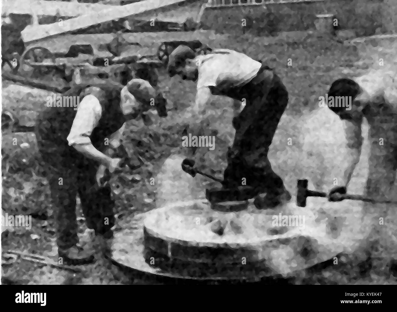 British Wheelwrights at work in the 1940's hammering a tyre onto a wheel c1940. Stock Photo