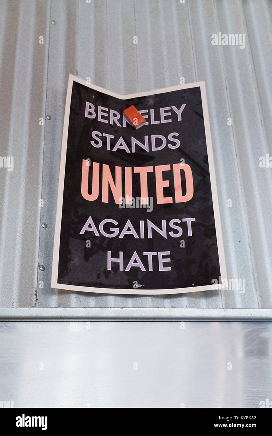 Inside a restaurant, workers have used a magnet to hang a poster reading 'Berkeley Stands United Against Hate' on the metal hood of a stove, part of a city-led response to 'alt right' organizations' 'anti Marxist' protests in the city, in the Gourmet Ghetto (North Shattuck) neighborhood of Berkeley, California, October 6, 2017. () Stock Photo