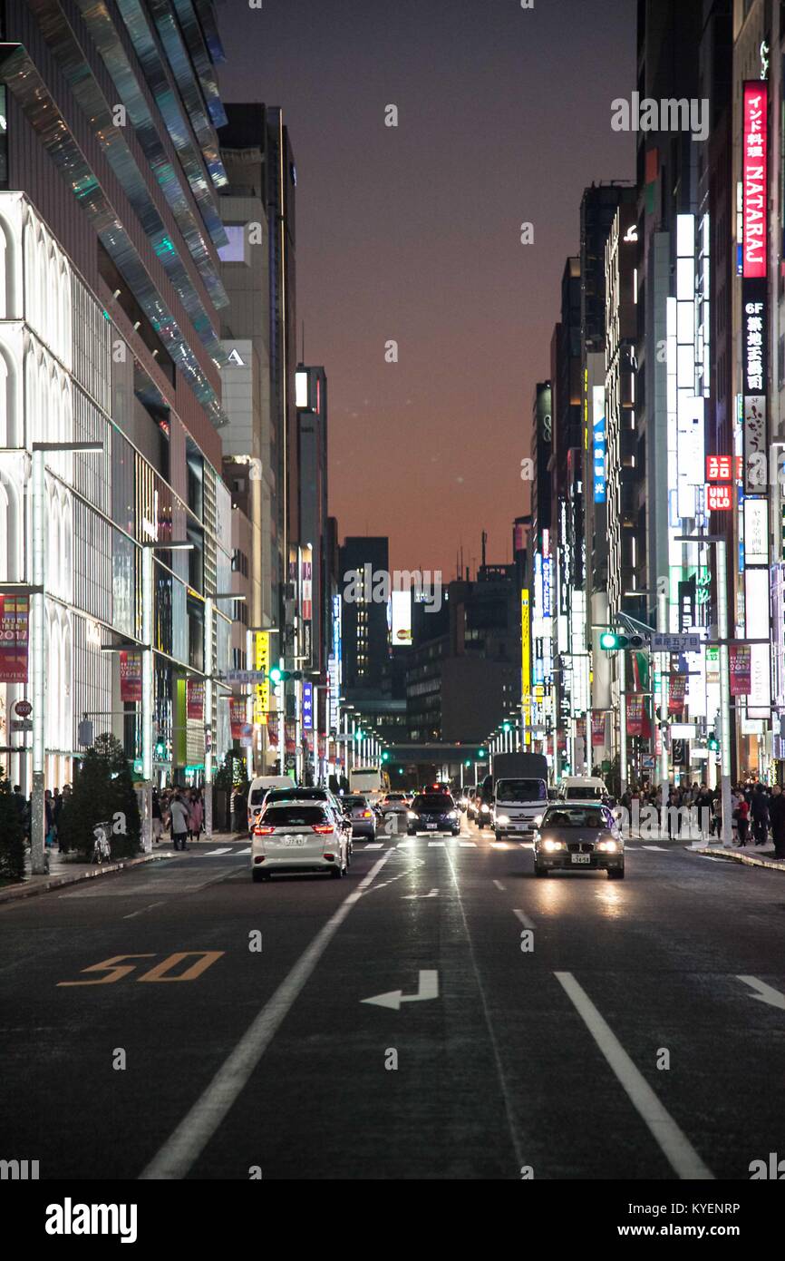 View down a busy road at night with billboards and cars in the Yurakucho Ginza district, known for its older restaurants and bars, in the Chiyoda Ward of Tokyo, Japan, November, 2017. () Stock Photo