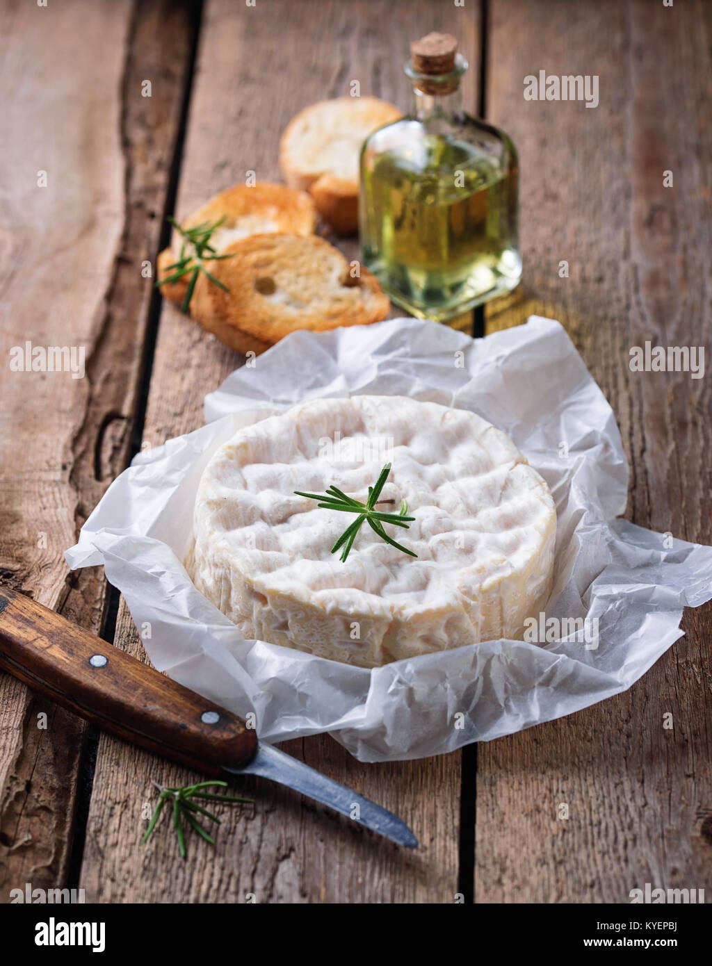 Camembert cheese with rosemary on wooden background Stock Photo