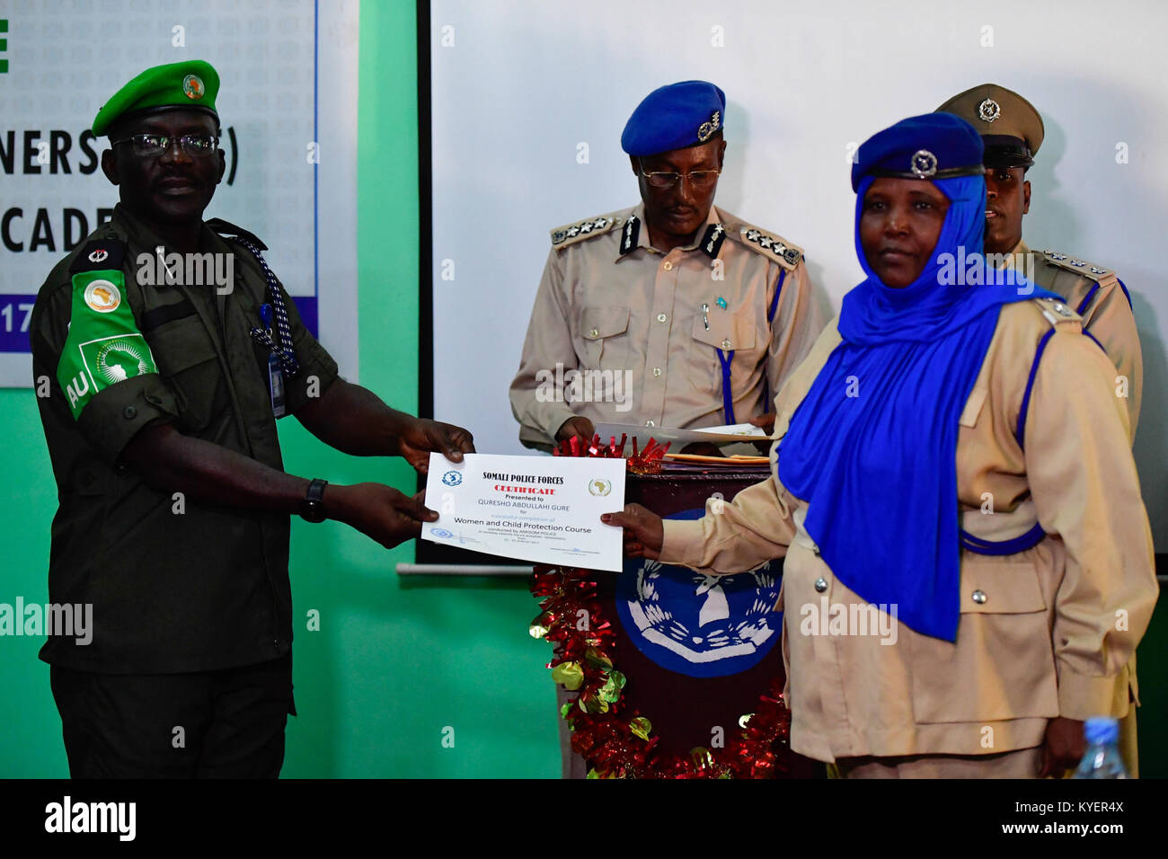 AMISOM Police Operations Co-ordinator, Assistant Commissioner of Police, Daniel Ali Gwambal handing a certificate to a Somali Police officer at the end of the joint Women and Child Protection and Basic Counter Insurgency courses in Mogadishu on Thursday, August 31 2017. AMISOM Photo/ Atulinda Allan Stock Photo