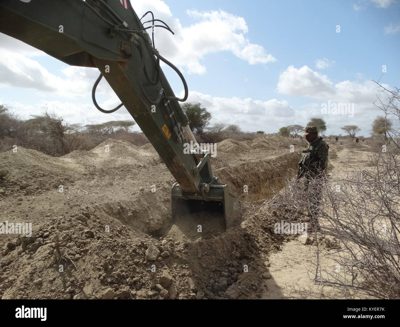 Kenyan engineers, as part of the African Union Mission in Somalia, dig trenches around an SNA camp as a way of thwarting VIED's used by the militant group Al Shabaab. There is currently an ongoing effort in Somalia to improve the security of SNA camps in order to help against attacks. AMISOM Photo Stock Photo