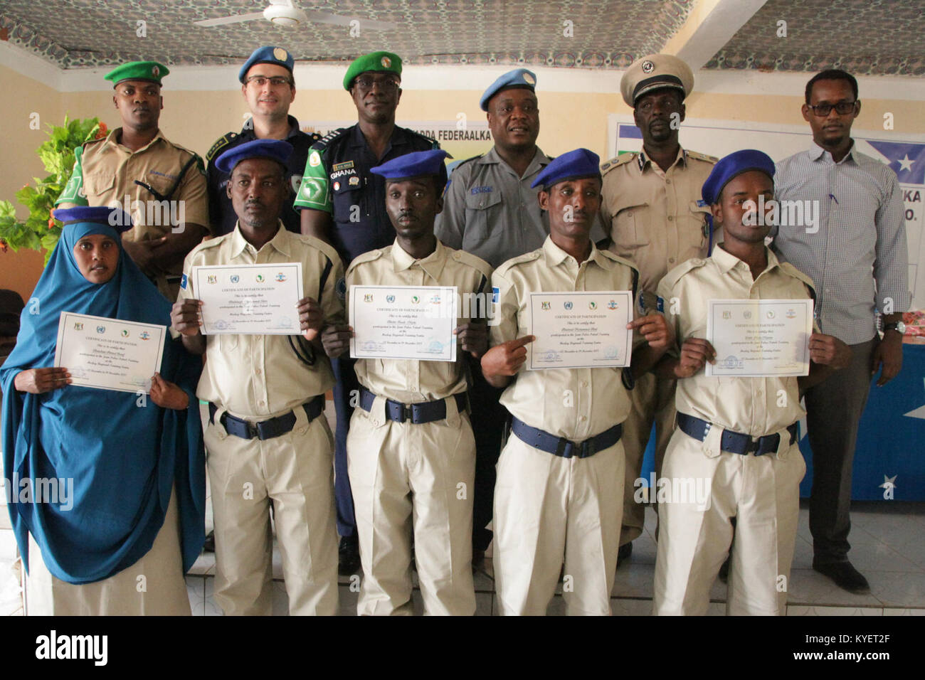 Police officers from Puntland and Galmudug State hold certificates in a group photograph with senior AMISOM, UN and Somali Police officers at the closing ceremony of a Joint Police Patrol Training in Gaalkacyo, Somalia on December 19, 2017. AMISOM Photo Stock Photo