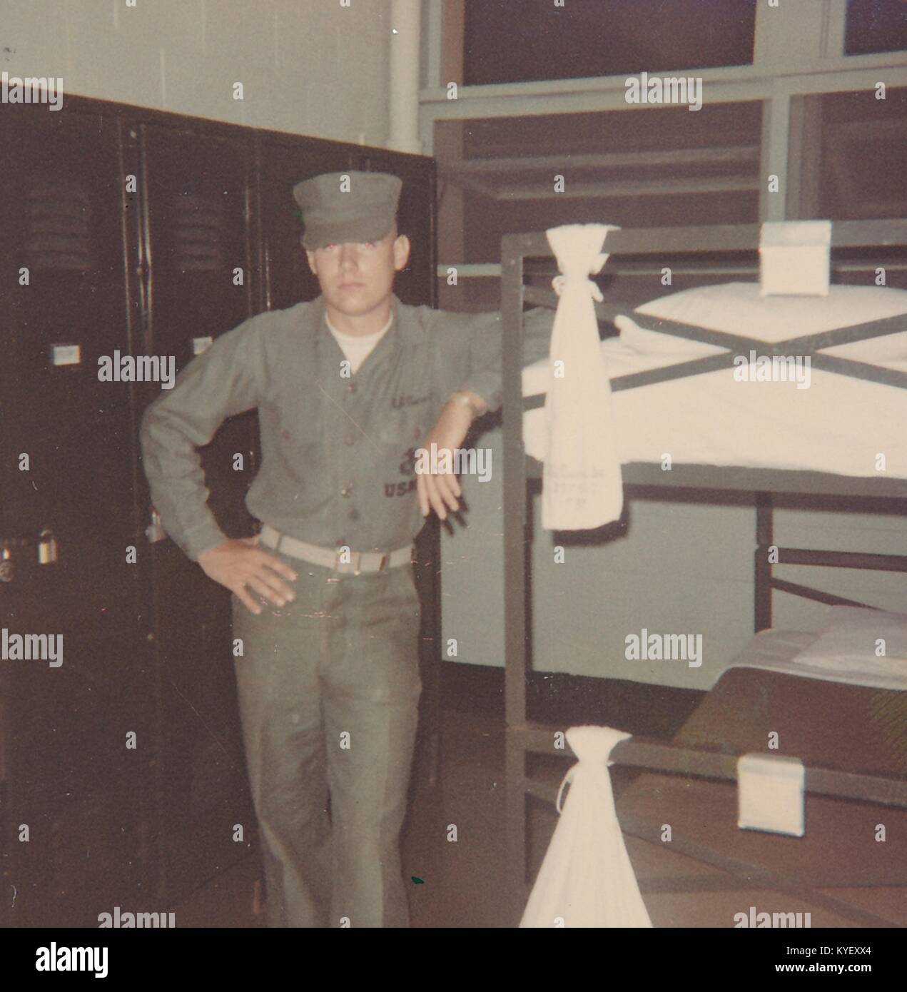 American soldier in uniform stands with his arm resting on the edge of a bunk bed in a barracks in Vietnam during the Vietnam War, 1968. () Stock Photo