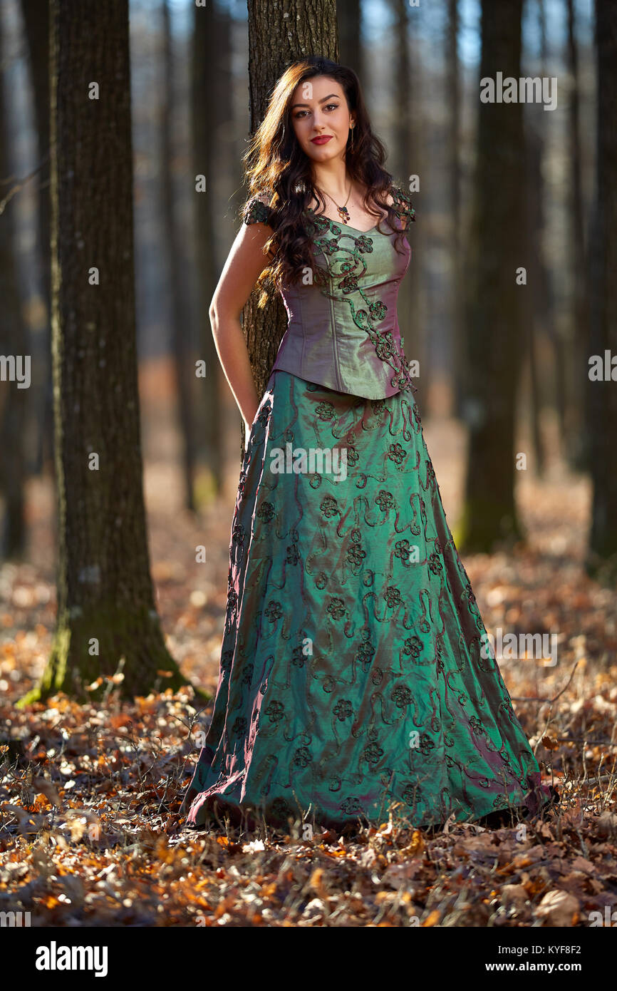 Portrait of a beautiful young woman in green dress in a forest Stock ...