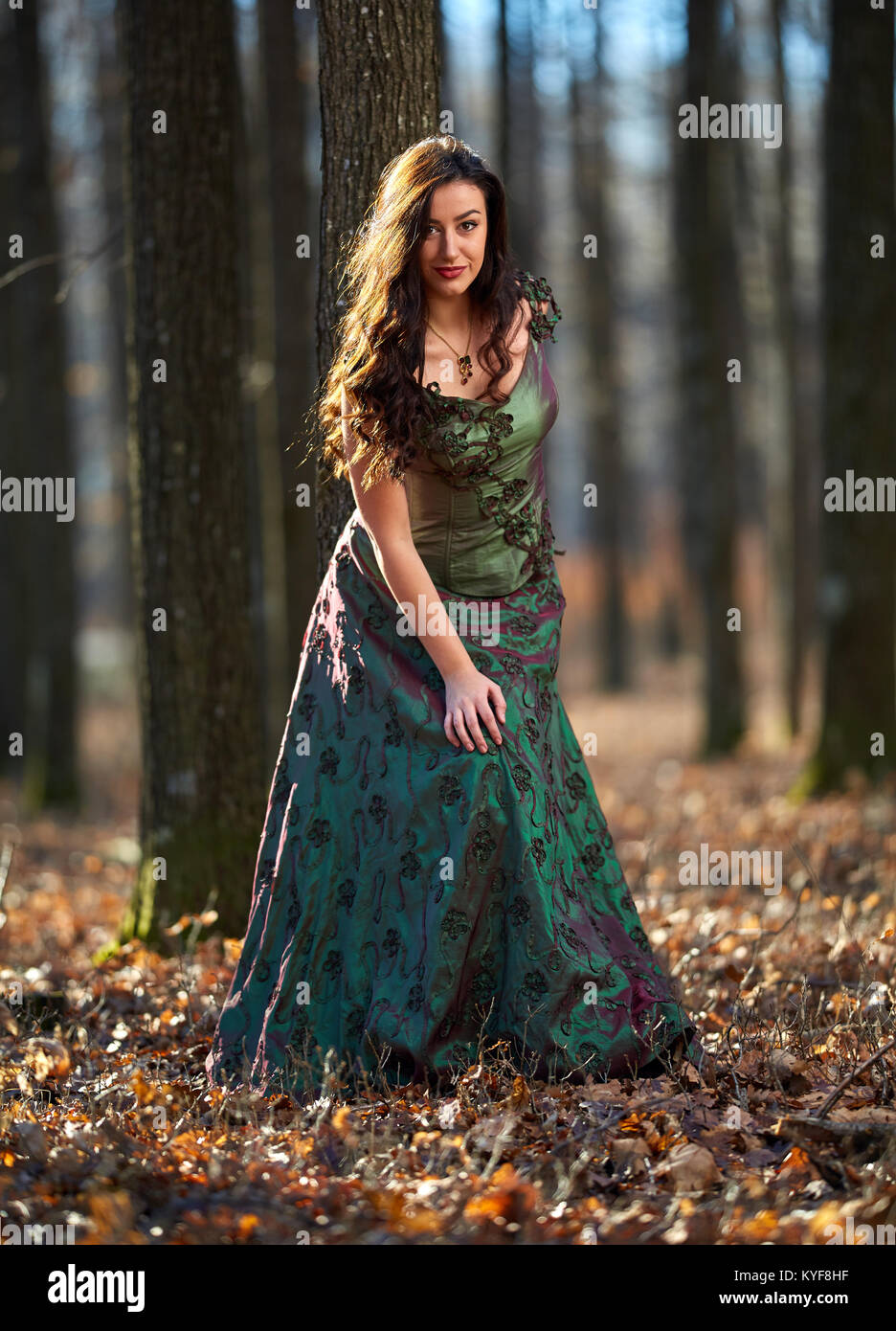 Portrait of a beautiful young woman in green dress in a forest Stock ...