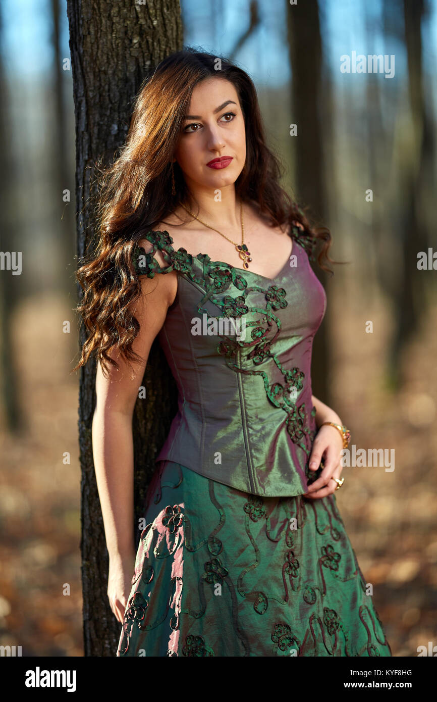 Portrait of a beautiful young woman in green dress in a forest Stock ...