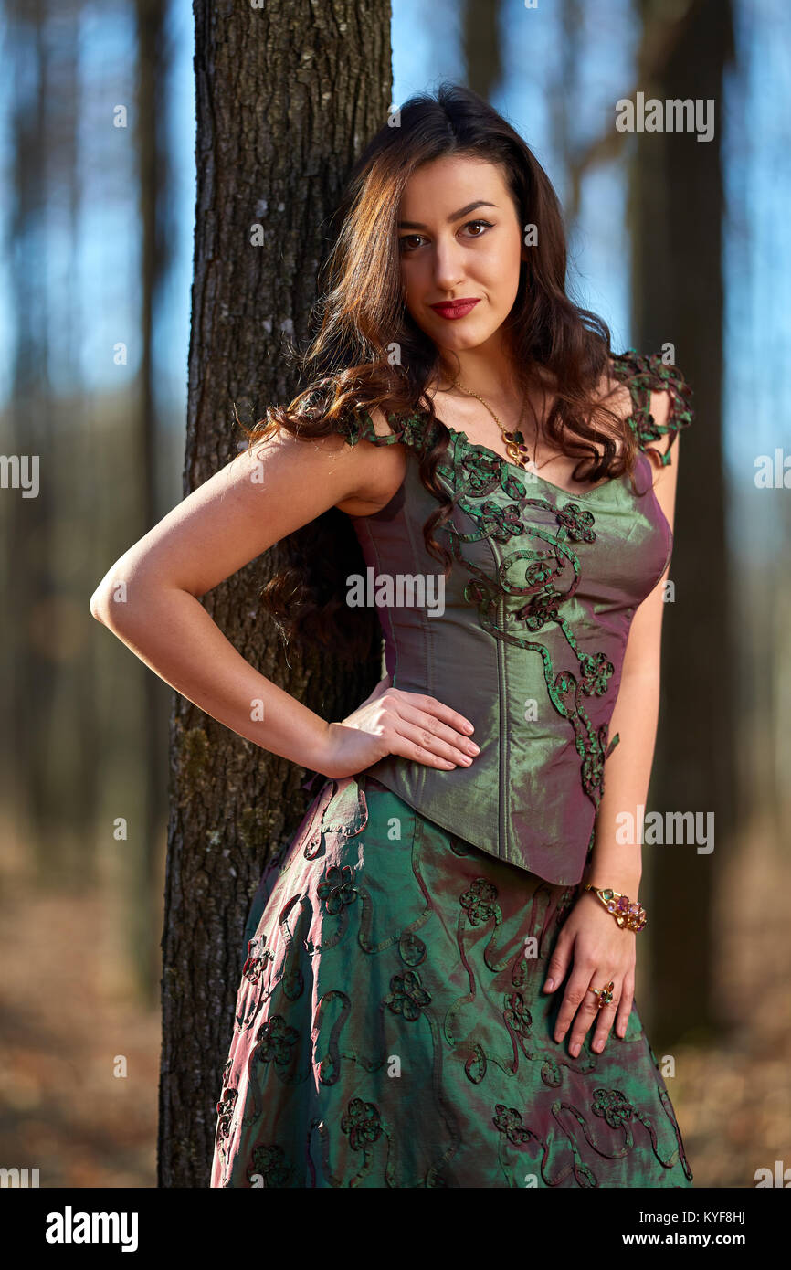 Portrait of a beautiful young woman in green dress in a forest Stock ...