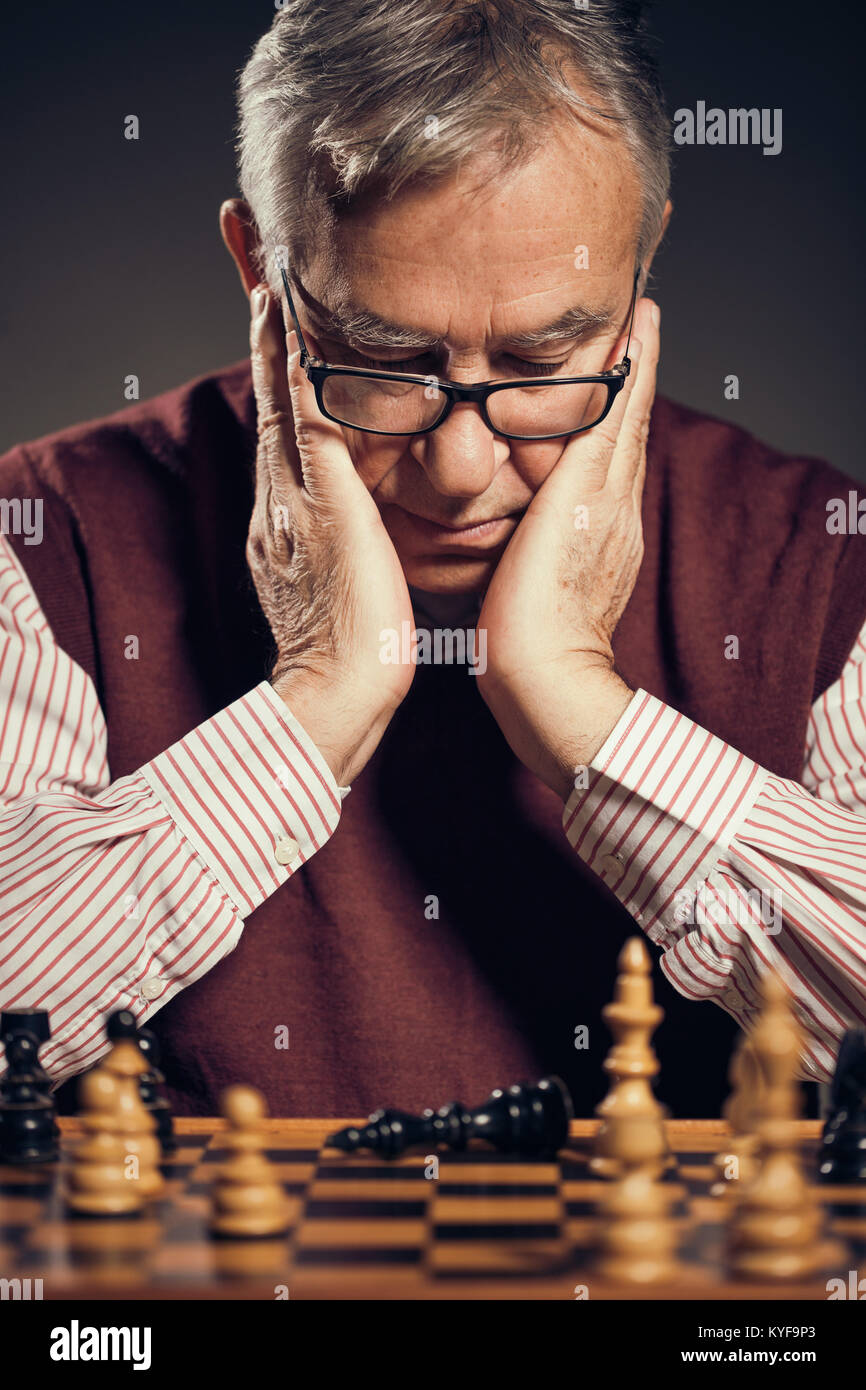 Portrait of senior man who capitulated in chess game. Stock Photo