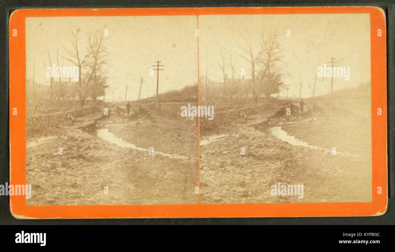 An image by Simpson showing a man standing on a road severely damaged ...