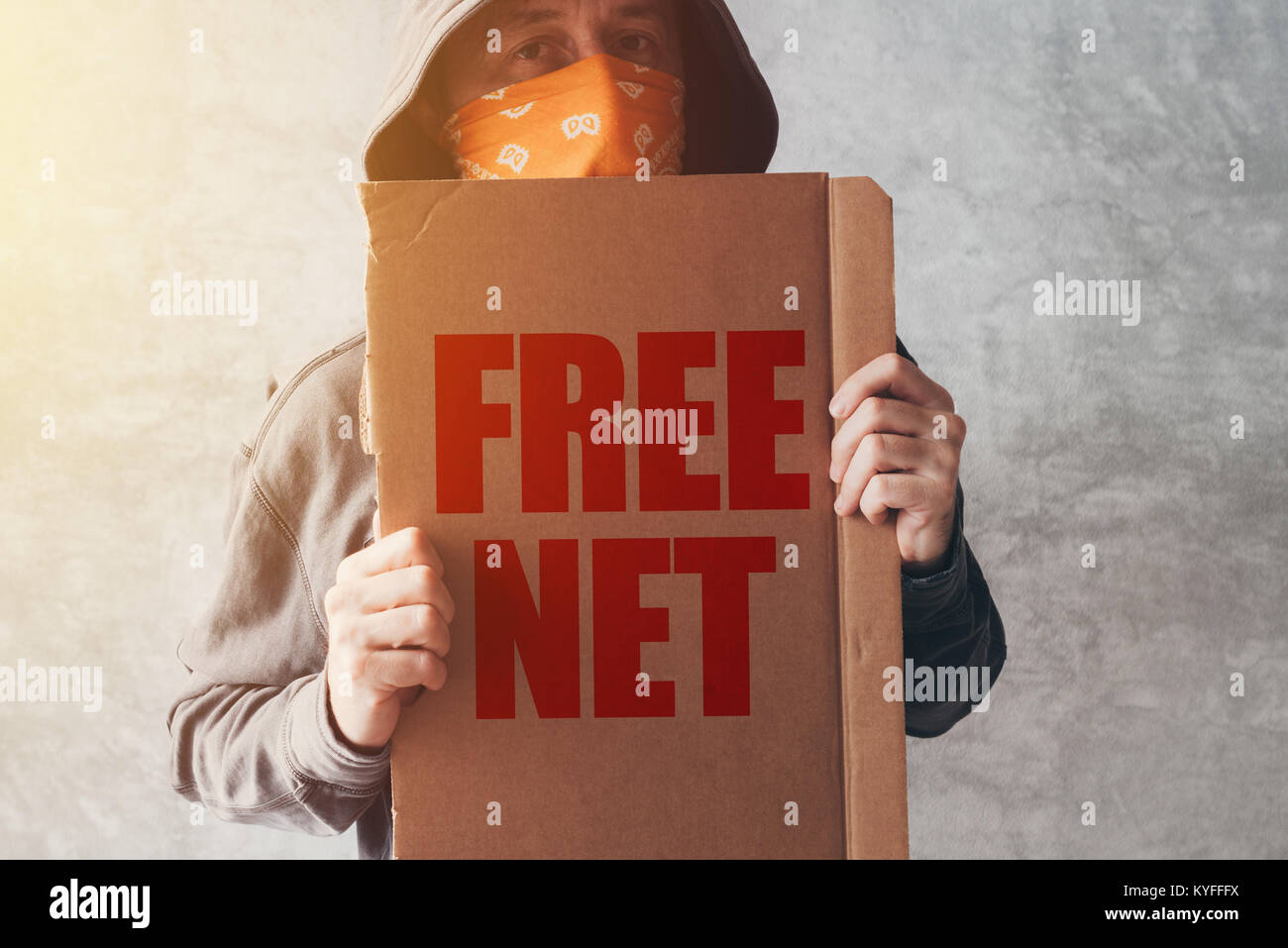 Hooded activist protester holding Free net protest sign. Man with hoodie and scarf over face taking part in activism and fighting for the cause. Stock Photo