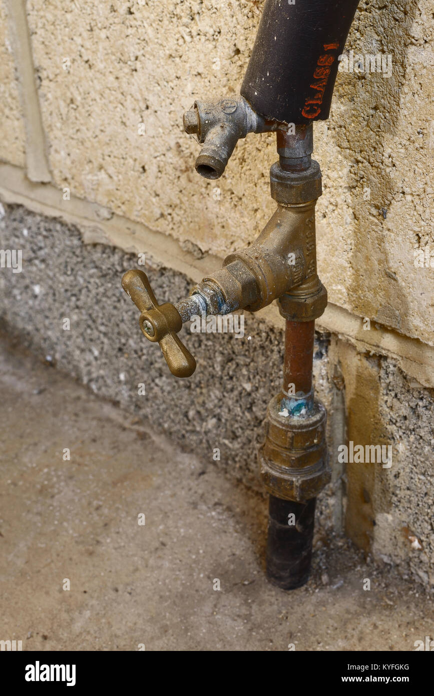 Domestic water main stop tap with a drain off valve inside a garage Stock  Photo - Alamy