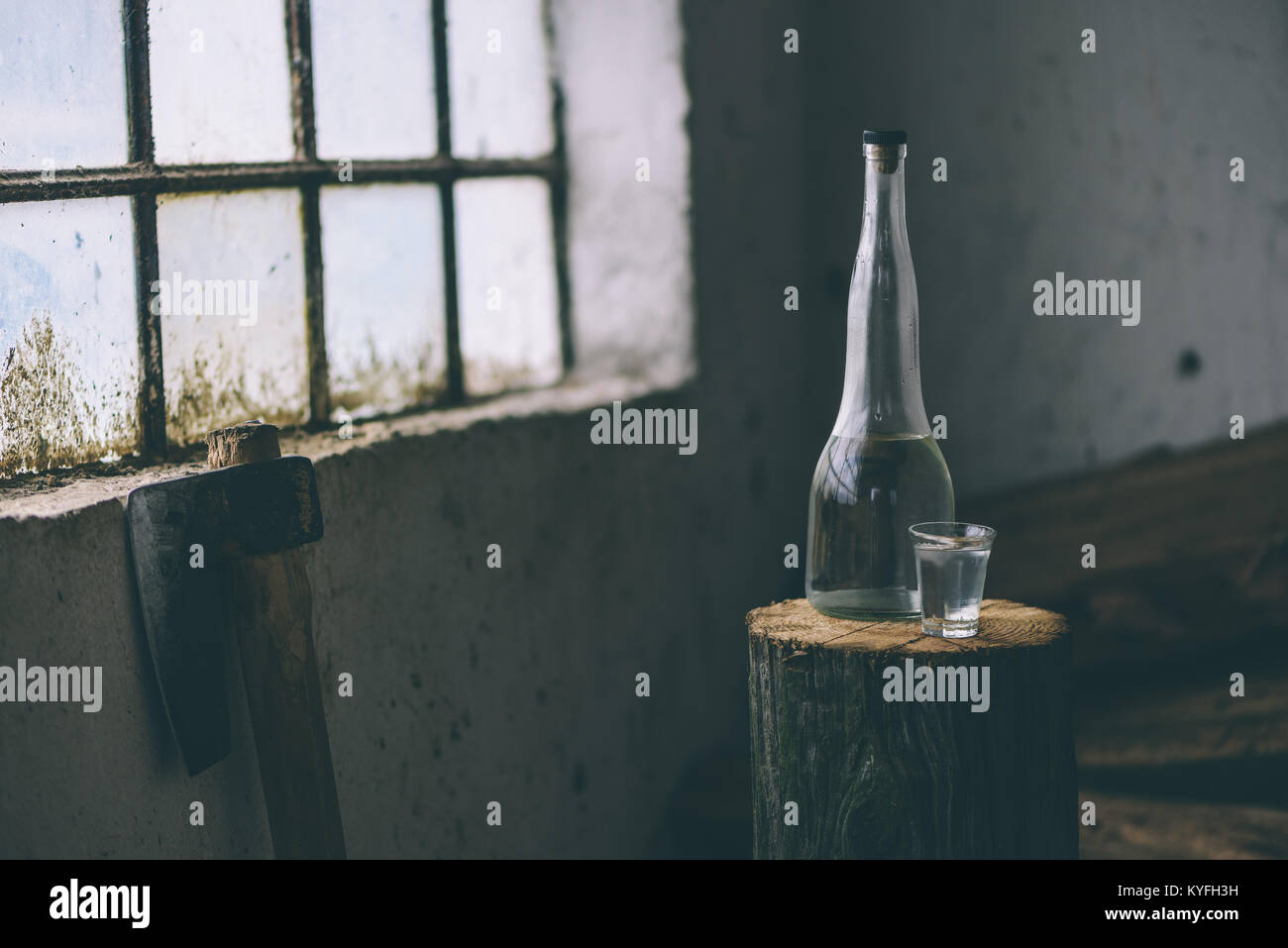 Strong alcohol drink in bottle with shot glass in traditional rustic retro toned atmosphere Stock Photo