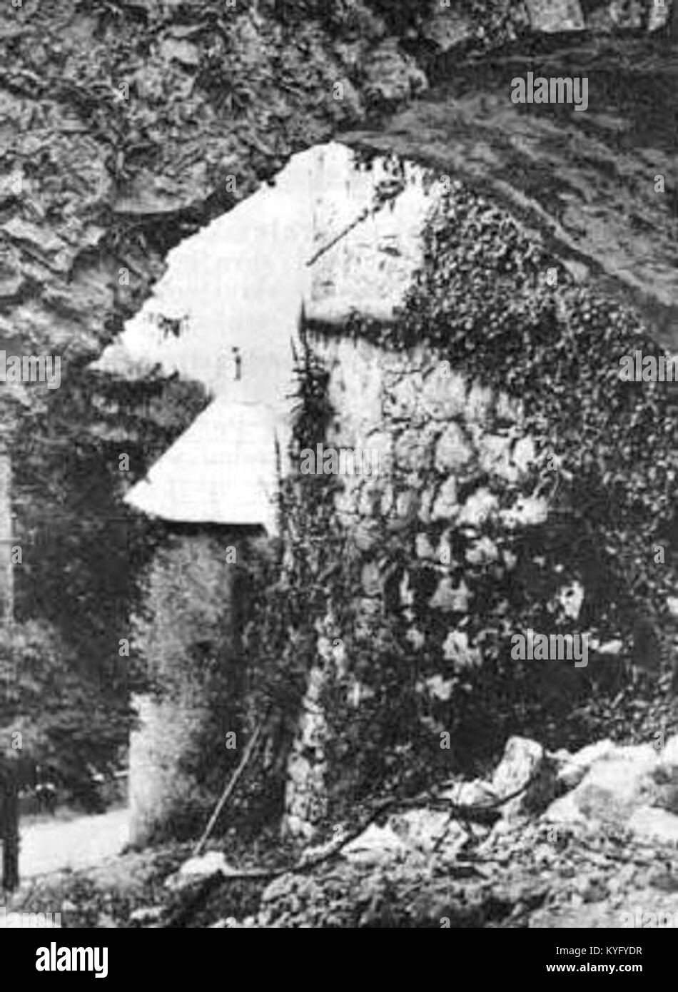 This image presents a view from beneath the entrance bridge at Hmeljnik, showcasing the fortified wall and old defensive tower, highlighting the site's historical military architecture in Slovenia. Stock Photo