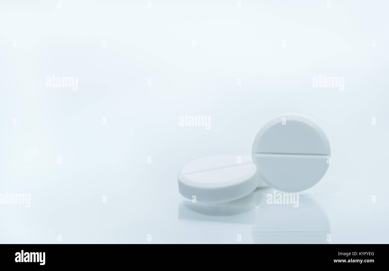 Macro shot of three white chewable tablets on white background with ...