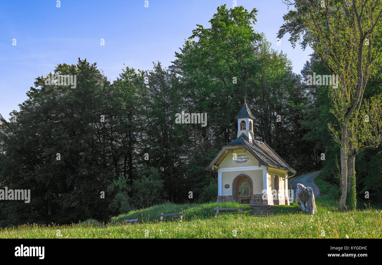 Small chapel on the hill in Berchtesgaden Bavarian national park. Panoramic stock photo with morning sunlight spring fresh greenery. Stock Photo