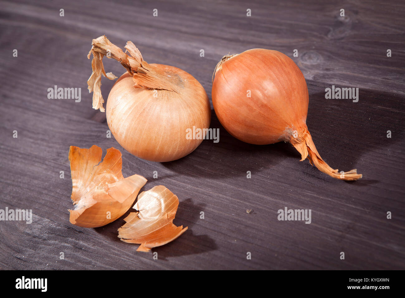 ripe onion on a brown wooden table Stock Photo - Alamy