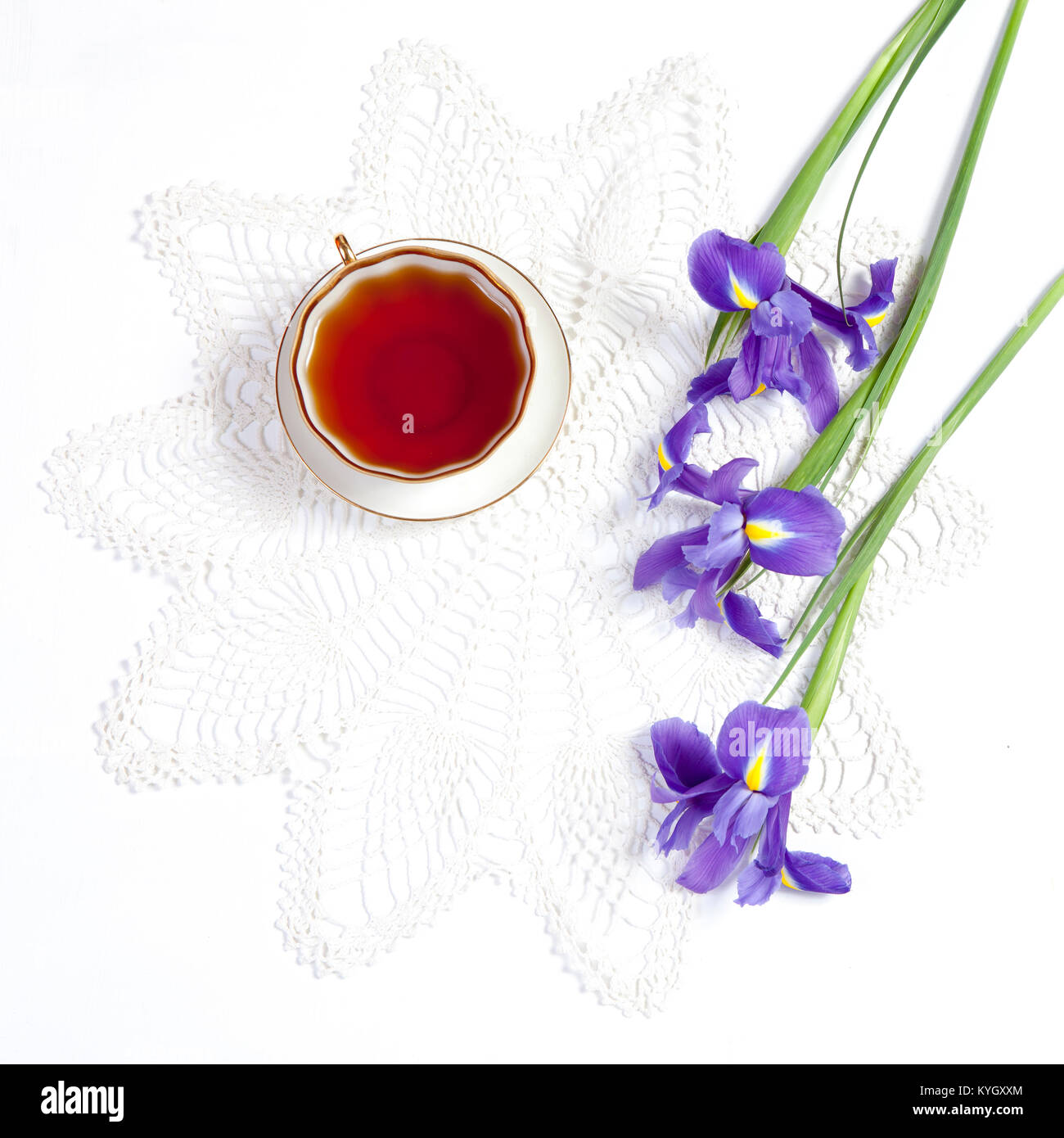 Violet Irises xiphium (Bulbous iris, sibirica) with cup of tea on white background with space for text. Top view, flat . Holiday greeting card for Val Stock Photo