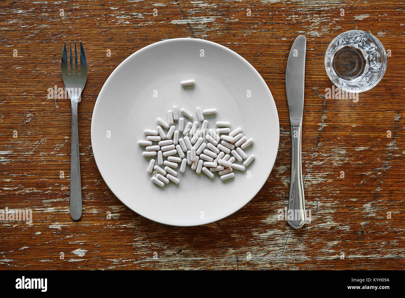 a bunch pf pills on plate controvery of food supplementation Stock Photo
