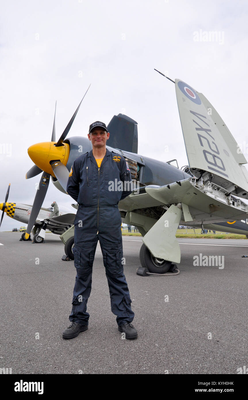 Lt Cdr Chris Götke (CO of the RN Historic Flight) was awarded the Air Force Cross for safely crash landing their Hawker Sea Fury - behind him at show Stock Photo