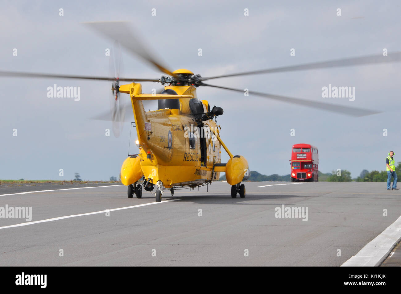 RAF Westland Sea King helicopter heading towards a red London bus on a taxiway at Biggin Hill Airport Stock Photo