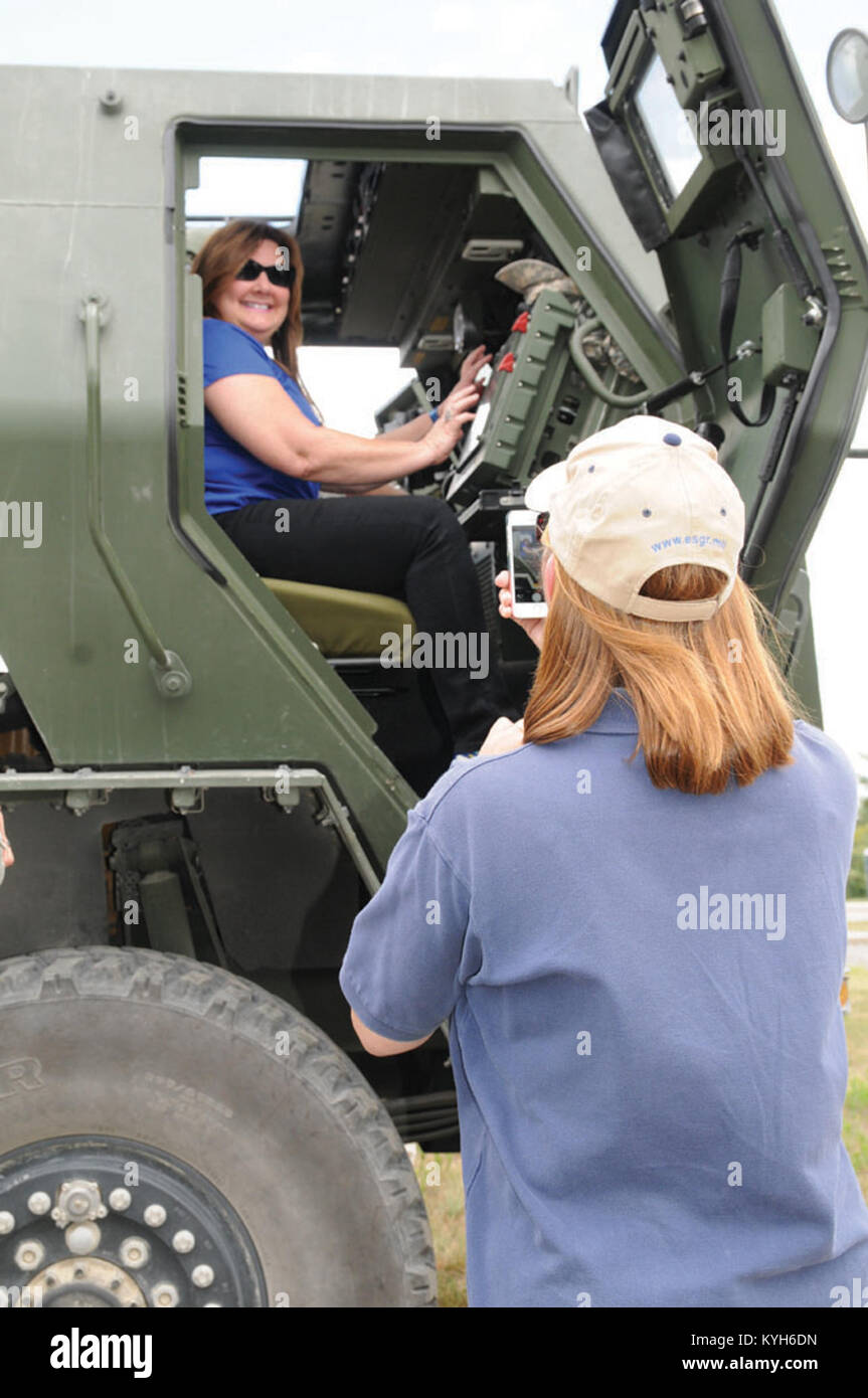 Tina Hammons, director of consumer sales, smiles while she poses in a High Mobility Artillery Rocket System as Rosemary Miller, program support technician, Employee Support of the Guard and Reserve, takes her picture during an annual &quot;Boss Lift&quot; event at Wendell H. Ford Regional Training Center, Greenville, Ky., 28 July, 2014. The Boss Lift allows civilian bosses to experience a day in the life of a KYNG Service member. (National Guard photo by Army Spc. Lerone Simmons 133rd MPAD) Stock Photo