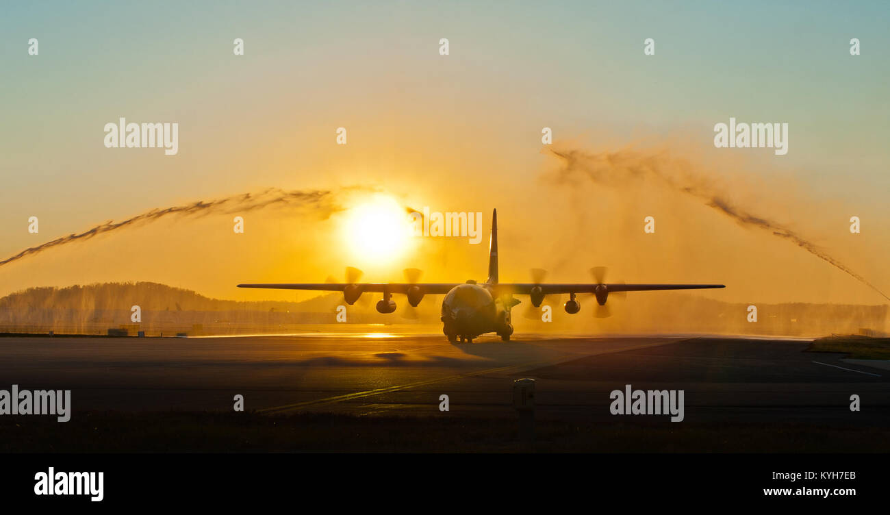 Fire trucks spray water in symbolic salute to a C-130 Hercules aircraft as it taxies onto the flight line of the Kentucky Air National Guard Base in Louisville, Ky., on Nov. 10, 2012, carrying 58 Kentucky Air Guardsmen returning from the Persian Gulf. The Airmen, all members of the Louisville-based 123rd Airlift Wing, spent the past four months flying airlift missions in support of U.S. military operations across the U.S. Central Command Area of Responsibility, which includes Iraq, Afghanistan and Northern Africa. (U.S. Air Force photo by Maj. Dale Greer) Stock Photo