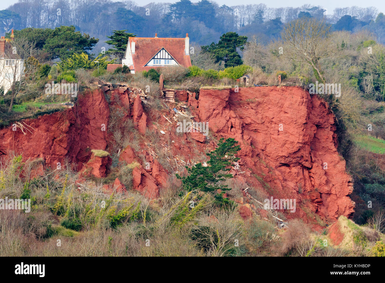 Red Permian breccia rockfall on the cliffs at Oddicombe beach, Babbacombe,Torquay, Devon. Wreckage from a destroyed house litter the slope. Stock Photo