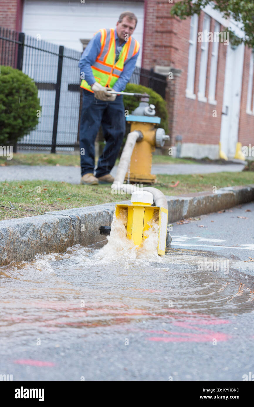 Water department technician opening fire hydrant to flush water mains