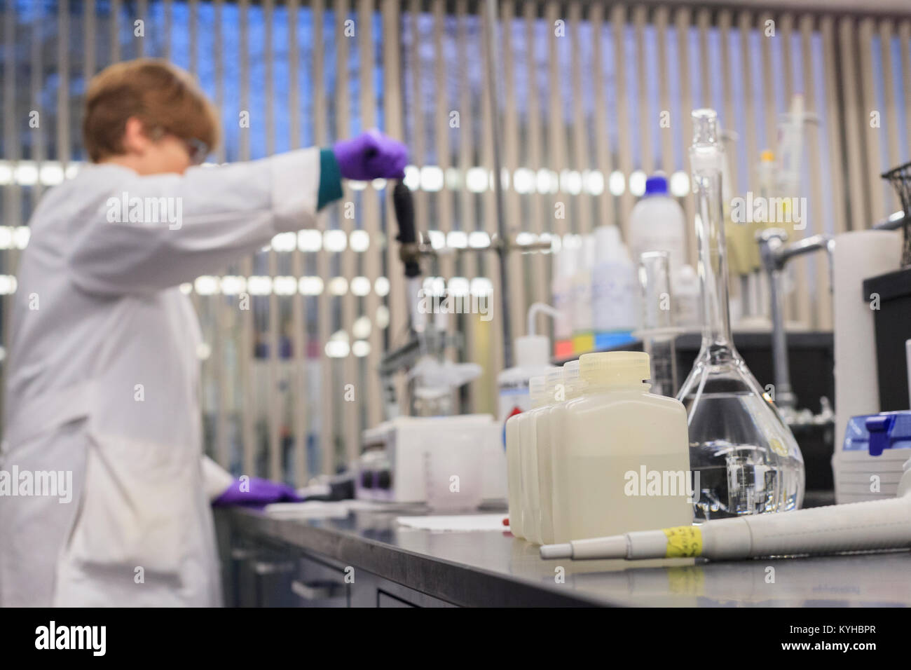Lab technician adding reagent to sample while measuring pH Stock Photo