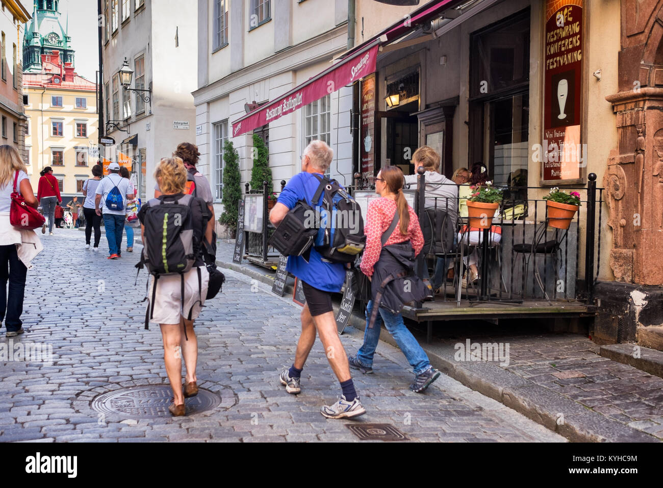 Stockholm busy street in historic Gamla Stan, or Old Town, popular with tourists. Crowds walking on cobblestone streets, eating in sidewalk cafes. Stock Photo