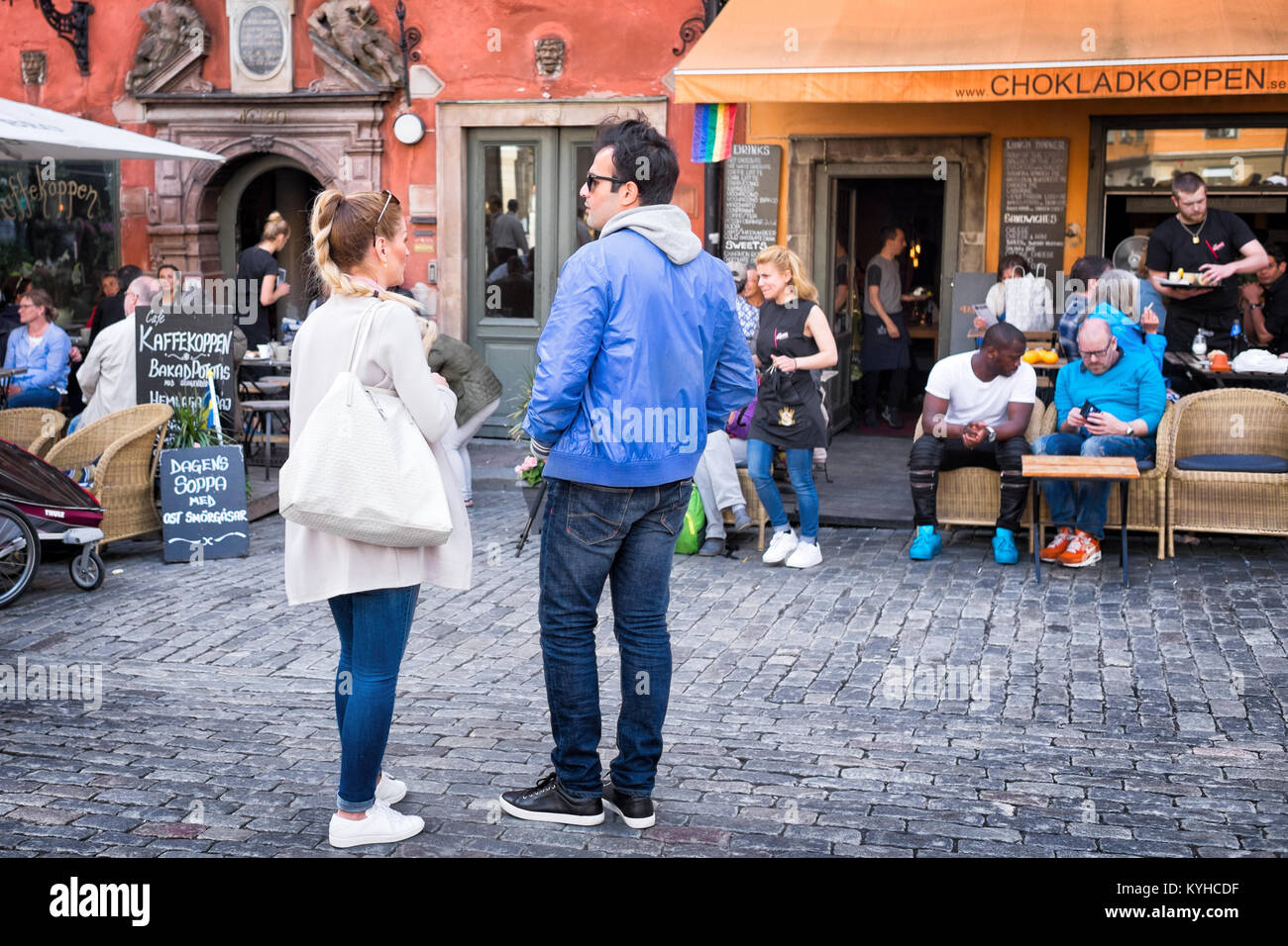 Stockholm sidewalk cafes in the picturesque historic neighborhood of Gamla Stan, also called Old Town. Couple in the foreground deciding where to eat. Stock Photo