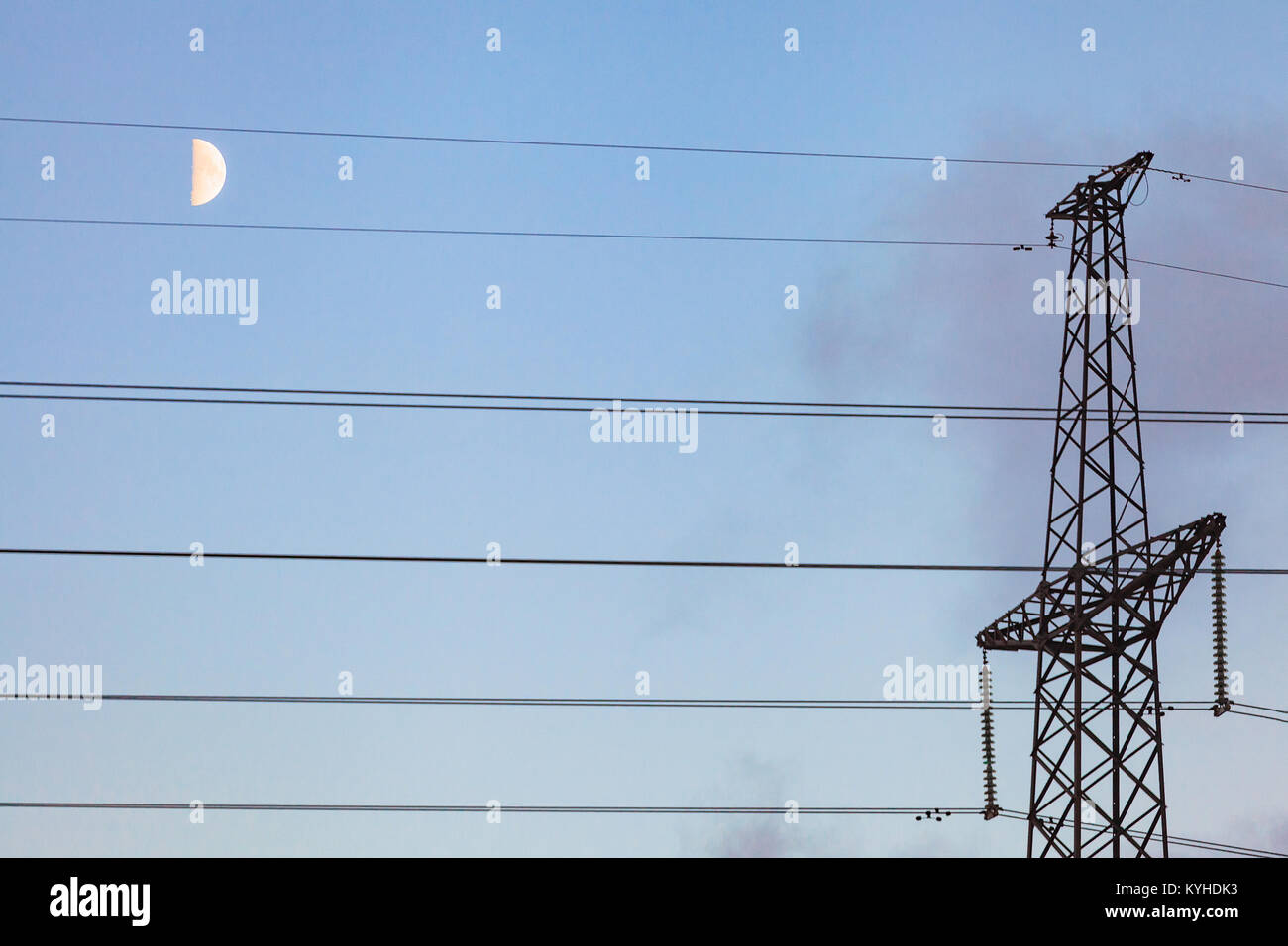 High voltage power lines against the background of the evening sky with the moon. Stock Photo