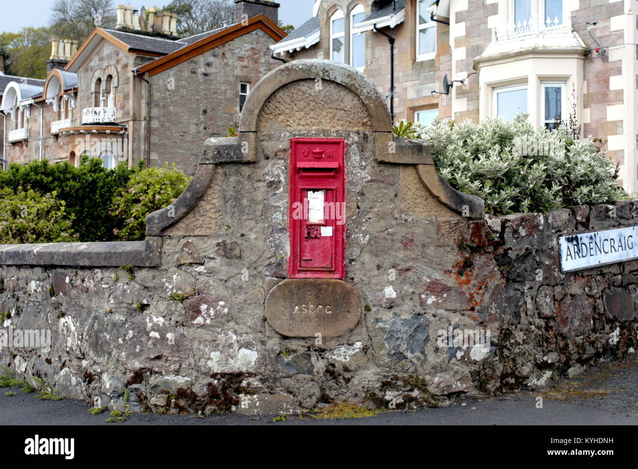 royal mail red postbox cast iron close up set in stonewall Ardencraig , Rothesay, United Kingdom Stock Photo