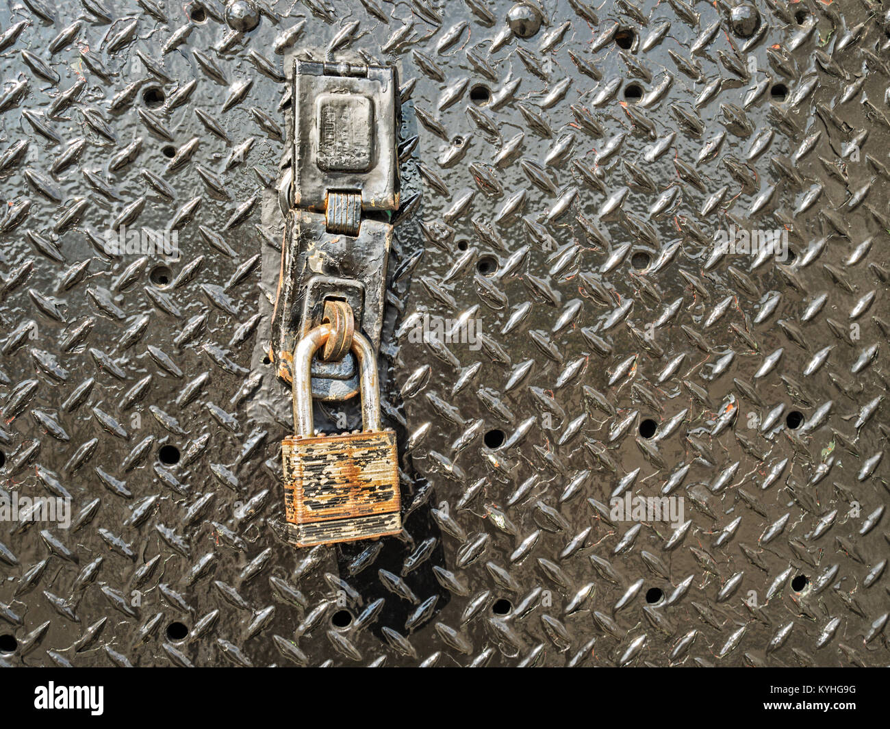 Old rusty iron padlock on metal door as symbol of safety security protection, secure data idea or rusted lock rust as unprotected, unsecured concept. Stock Photo