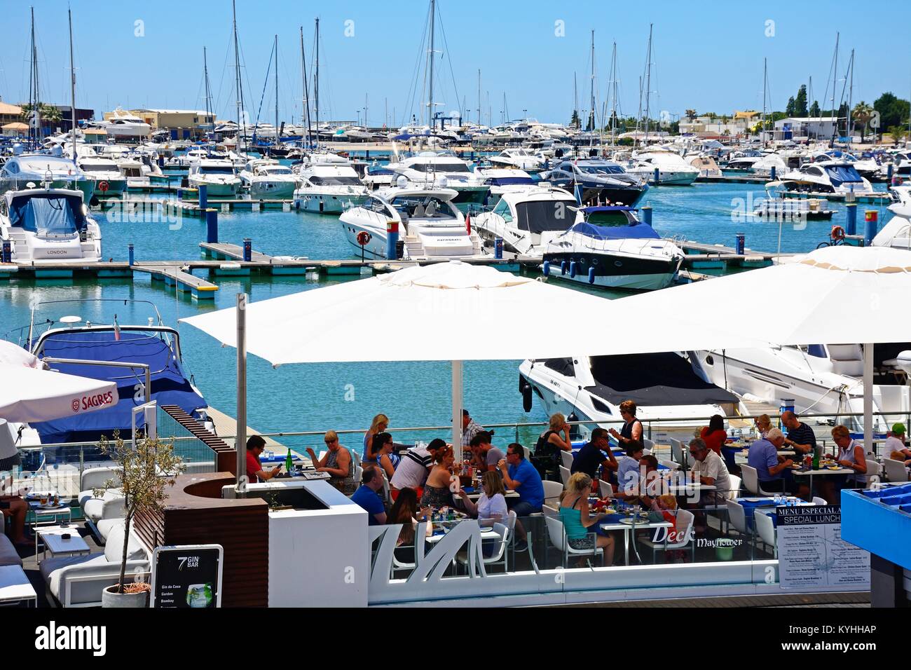 Luxury boats moored in the marina with waterfront restaurants in the foreground, Vilamoura, Algarve, Portugal, Europe. Stock Photo