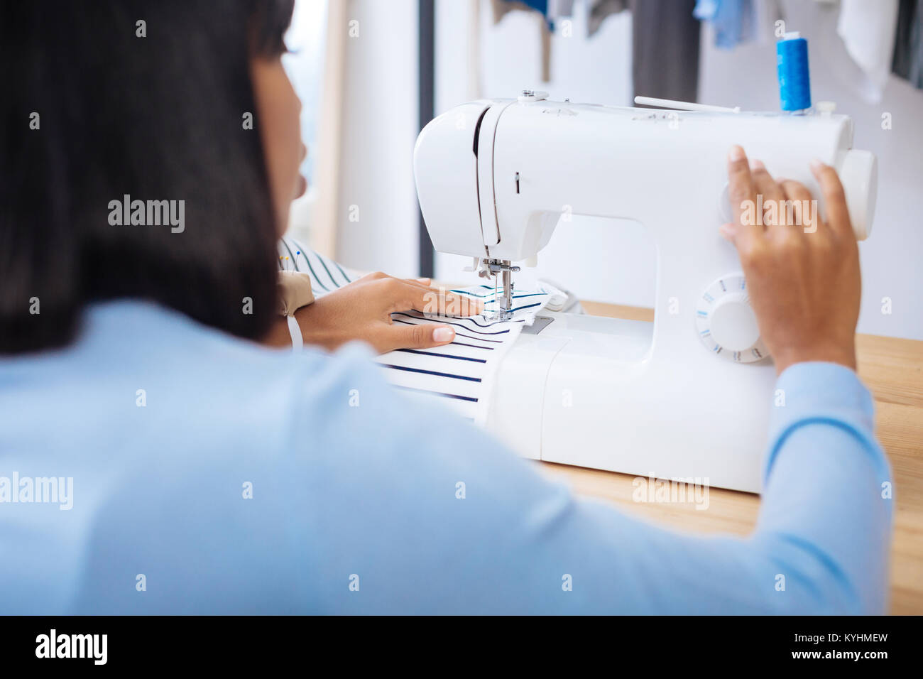 Careful tailor changing speed on her modern sewing machine Stock Photo
