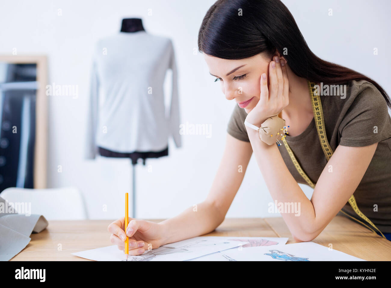 Calm young woman looking pleased while drawing Stock Photo