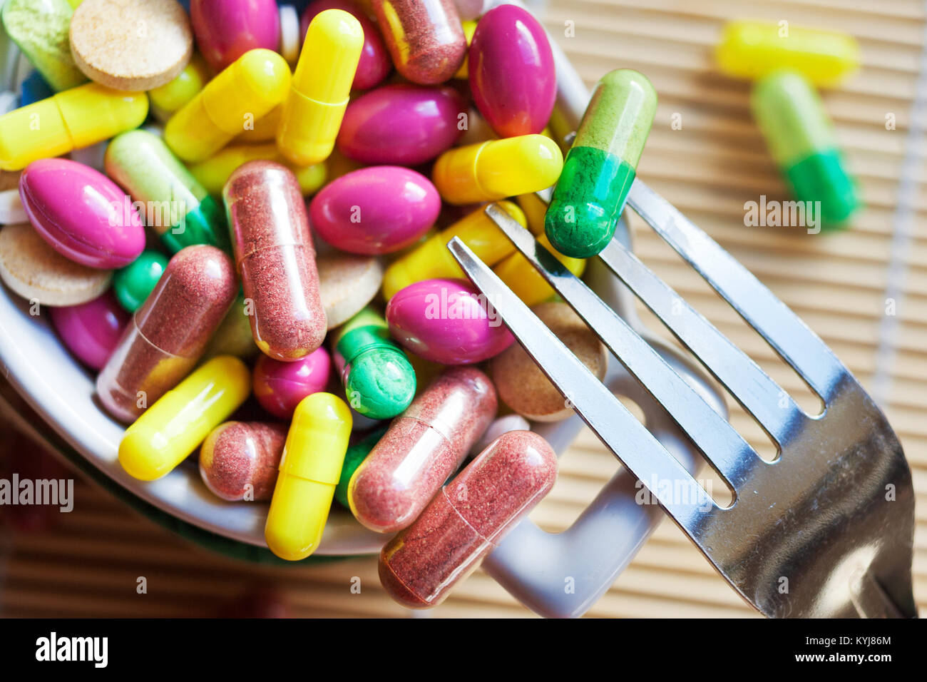 health care and wellness - diet pills and loosing weight - various tablets in a pot with forks Stock Photo