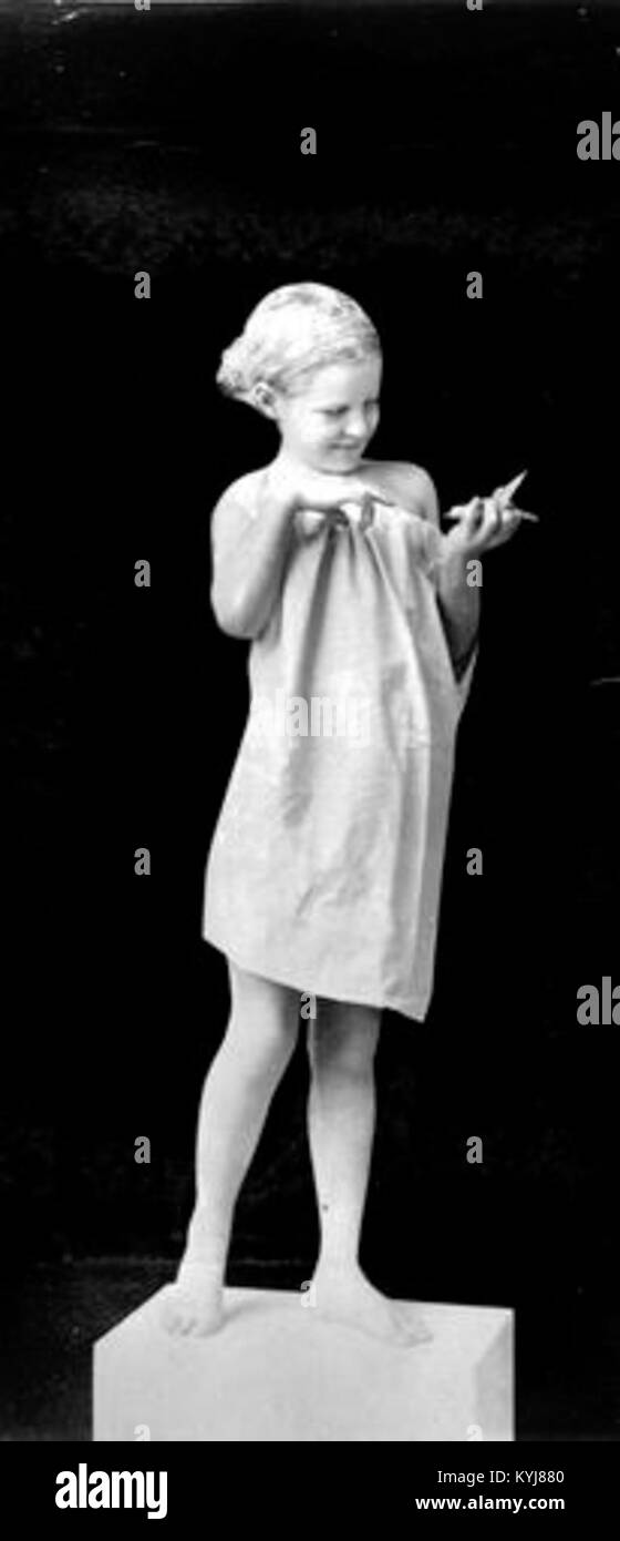 A statue depicting a girl holding a bird, capturing the delicate balance between human and nature in the form of a life-inspired sculpture. Stock Photo
