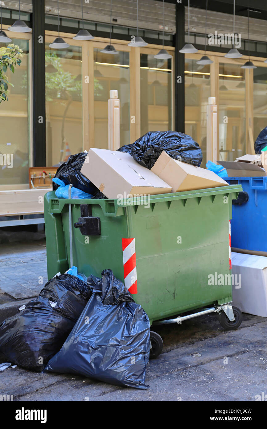 Overflow of Trash in Garbage Container and Black Bags Stock Photo