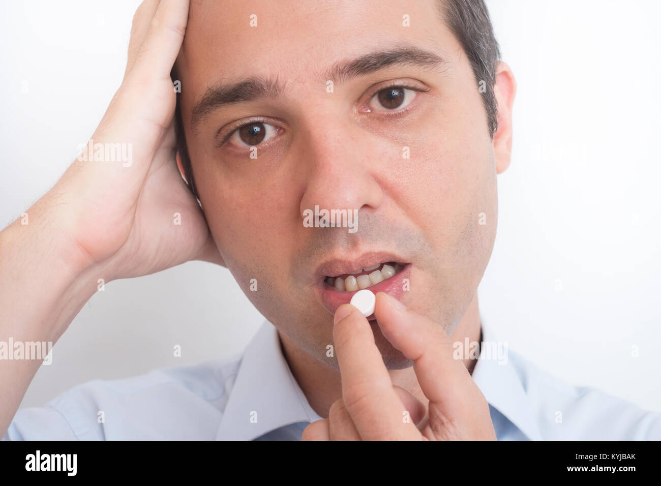 Sick man eating aspirin pill medication Stock Photo Alamy